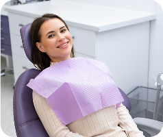 paciente sonriendo en silla de dentista